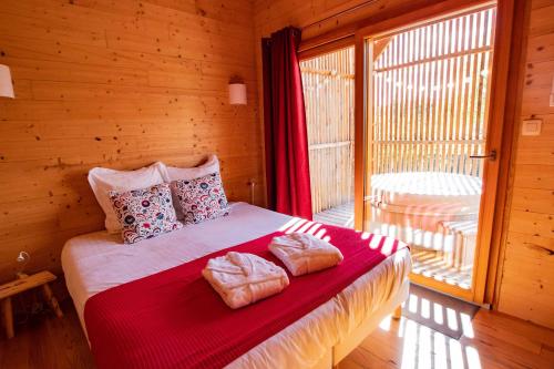 VirigninLes Lodges de la ViaRhôna / cabane-spa的一间卧室配有一张床,上面有两条毛巾