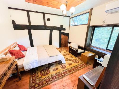 十日町古民家宿Tani House Itaya -セルフチェックイン的一间设有床铺的卧室,位于带窗户的房间内