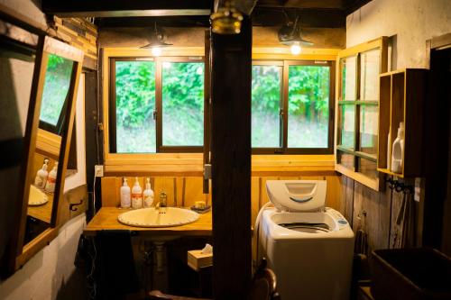 十日町古民家宿Tani House Itaya -セルフチェックイン的一间带卫生间和水槽的小浴室