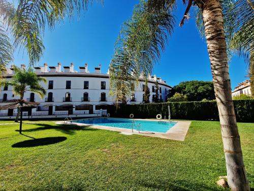 贝莱斯德韦瑙达利亚贝莱斯纳扎里公寓的一座白色的大建筑,设有游泳池和棕榈树