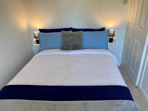 亨斯坦顿Close to beach. Two bed compact flat.的一张配有蓝色和白色床单及枕头的大床