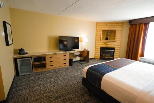 桑达斯基Sawmill Creek by Cedar Point Resorts的酒店客房配有一张床和一张书桌及一台电视