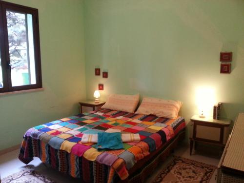 斯克佩罗Villa Sarmuci, Mare Natura Relax的一间卧室配有一张带彩色毯子的床