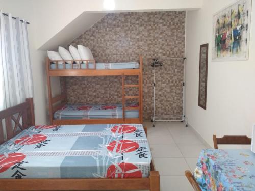 卡拉瓜塔图巴Quitinetes Canto Verde Caraguá的一间卧室配有两张双层床。