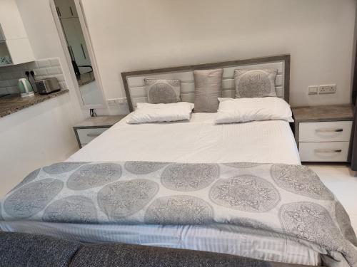 塞拉莱Hawana Salalah Laguna Studio的卧室配有一张带灰色和白色棉被的大床
