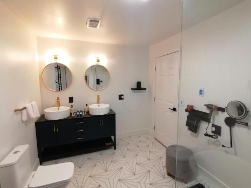 坎伯兰The Dacha. Cumberland vacation的浴室配有2个盥洗盆、卫生间和浴缸。