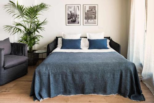 阿利坎特Apartamento Bguest con terraza的一间卧室配有一张带蓝色枕头的床和一把椅子