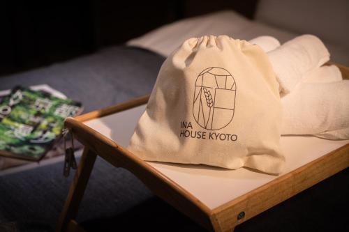 京都INA HOUSE Nijojo的一张带毛巾的桌子上的一个袋子