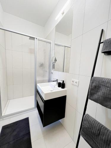维也纳Sissi West的白色的浴室设有水槽和淋浴。