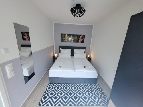 巴德克洛斯特尔劳斯尼茨Ferienwohnung Holzland的一间小卧室,配有一张白色的床和一个吊灯