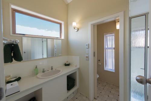 奥克兰霍维克汽车旅馆的一间带水槽和镜子的浴室以及窗户。
