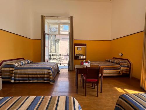 墨西哥城伊莎贝尔酒店的客房设有两张床、一张桌子和一扇窗户。