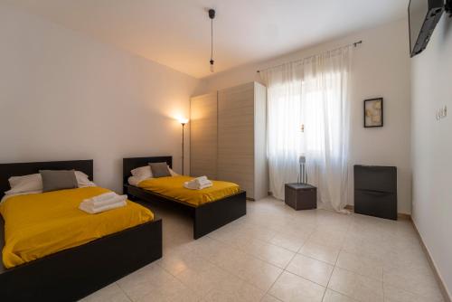 维罗纳Shiny Home Verona的一间卧室设有两张床和窗户。