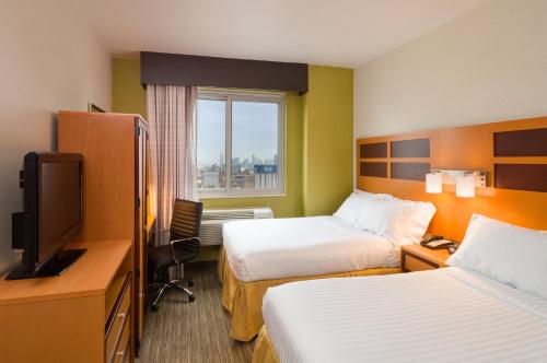 纽约快捷假日酒店 - 时代广场店的酒店客房设有两张床和电视。