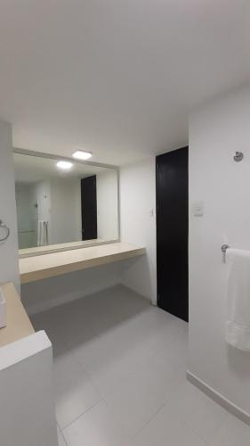 巴兰基亚巴比克莱尔套房公寓式酒店的白色的浴室设有镜子和水槽