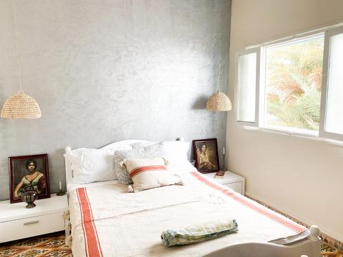 西迪伊夫尼El MOJA SURFHOUSE的一间卧室设有一张床和一个窗口