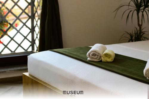 普里什蒂纳Museum Hotel的酒店客房的床上配有2条可移动毛巾