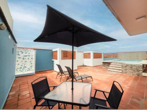 韦拉克鲁斯Hotel Meson del Barrio的庭院配有椅子和桌子及遮阳伞