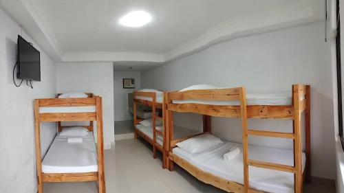 长滩岛萝拉小屋酒店的客房设有三张双层床和电视。