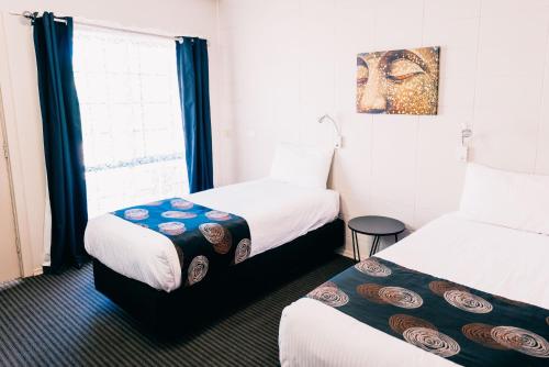 奥古斯塔港一品红汽车旅馆的酒店客房设有两张床和窗户。