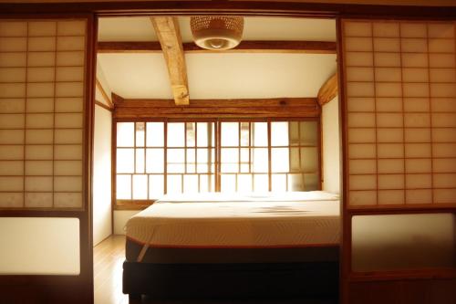 壹岐市島宿糸的一间带床的卧室,位于带窗户的房间内
