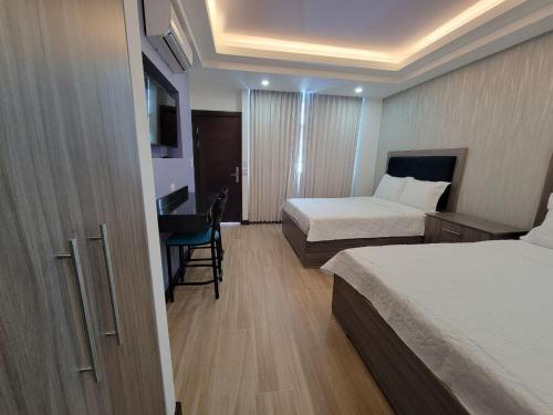 蓬塔雷纳斯Hotel Cayuga的酒店客房配有两张床和一张书桌