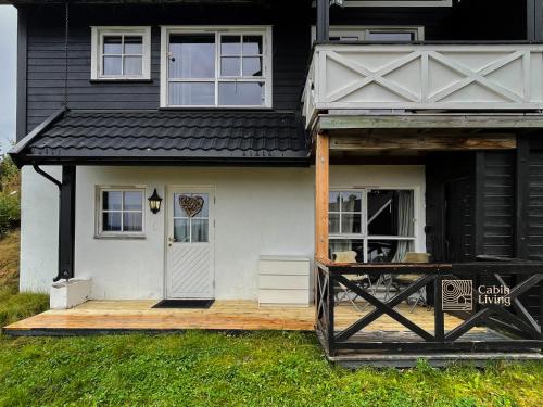 特吕西尔Nice apartment with Sauna and ski in out Trysil的一座带门廊和木甲板的房子