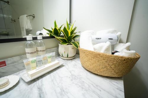 塞班Paradiso Resort & Spa的浴室柜台配有一篮毛巾和镜子