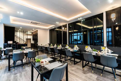 芭堤雅市中心One Patio Hotel Pattaya - SHA Extra Plus的餐厅设有桌椅和窗户。