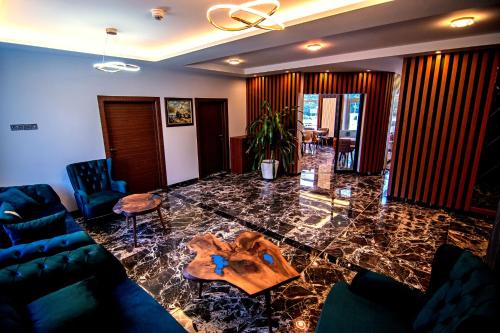 埃伯斯瓦尔德菲诺亚曼酒店的客厅配有玻璃桌和蓝色沙发
