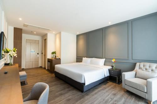 芭堤雅市中心One Patio Hotel Pattaya - SHA Extra Plus的配有一张床和一把椅子的酒店客房