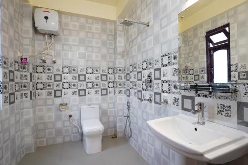 甘托克Hotel White Lotus Gangtok的白色的浴室设有水槽和卫生间。
