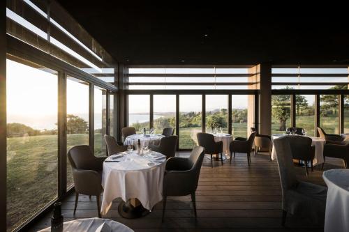 锡库利亚纳ADLER Spa Resort SICILIA的餐厅设有桌椅和大窗户。