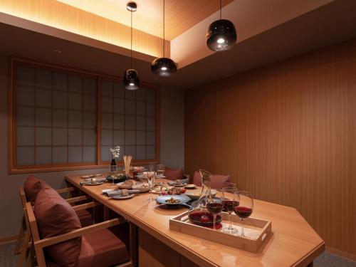 东京MIMARU SUITES Tokyo ASAKUSA的用餐室配有带酒杯的长桌