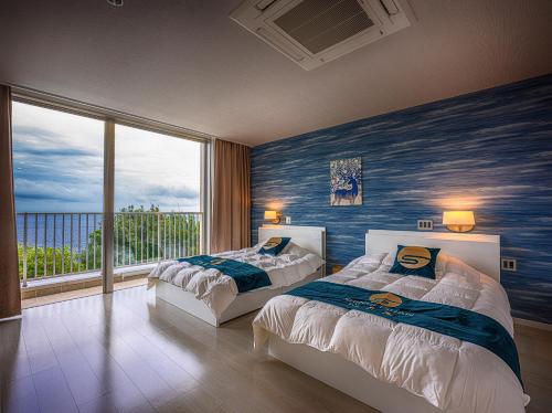 白滨Shingetsuann Shirahama的一间卧室设有两张床和大窗户