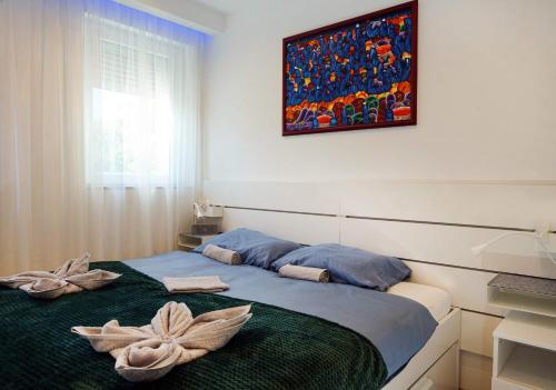 韦莱姆Alpok-Spirit Apartment – Velem的一间卧室配有一张床,上面有两条毛巾