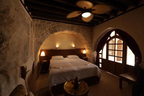 HalfetiCEVHER KONAĞI的卧室配有一张石墙内的大床