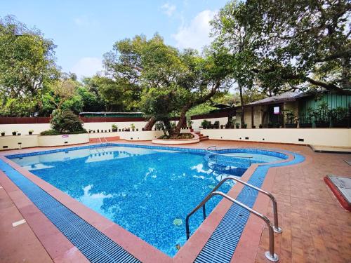 马哈巴莱斯赫瓦尔Regenta MPG Club Mahabaleshwar的庭院里的一个蓝色海水游泳池