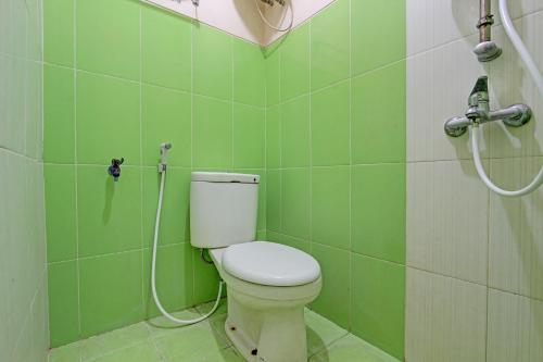 日惹OYO 91803 Gita Graha Guest House Syariah的绿色浴室设有卫生间和淋浴。