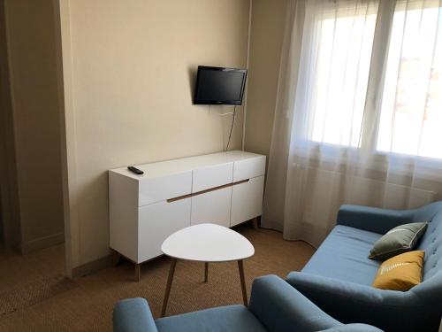莱萨布勒-多洛讷里歇家庭旅馆的客厅配有蓝色的沙发和电视