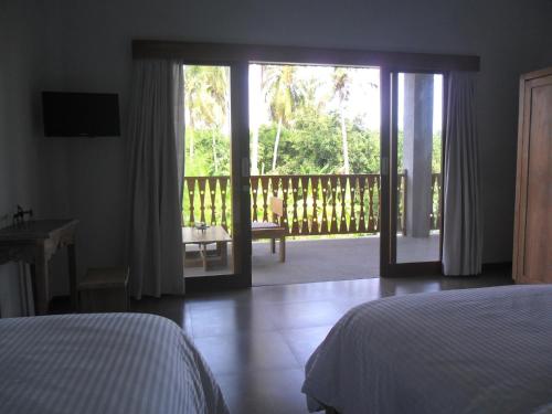 罗威那居布鲁酒店的一间卧室设有一张床和一个滑动玻璃门