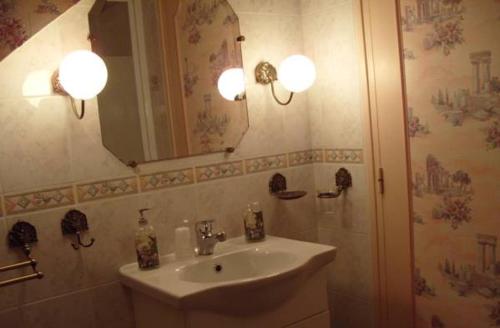Sommervieu莱普茨贝森诺曼底旅馆的一间带水槽和镜子的浴室