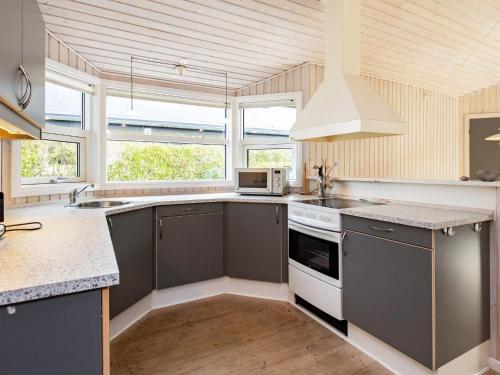 Frørup8 person holiday home in Fr rup的厨房配有灰色橱柜和白色炉灶烤箱