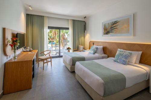 沙姆沙伊赫Amphoras Beach的酒店客房配有两张床和一张书桌