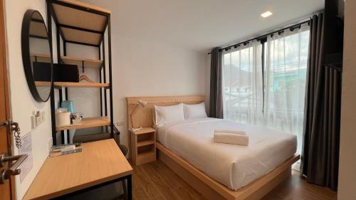 卡马拉海滩B3 HOUSE的一间小卧室,配有床和窗户