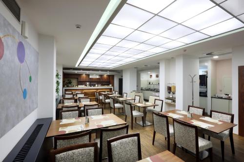 布拉格阿马里亚特杰罗姆酒店的用餐室配有木桌和椅子