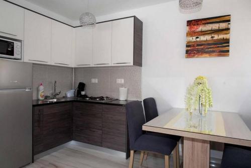 达鲁瓦尔Apartments Oaza的厨房配有白色橱柜和桌椅
