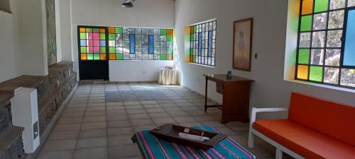 La CarreraTADASANA CASA DE CAMPO的彩色玻璃窗和沙发的房间
