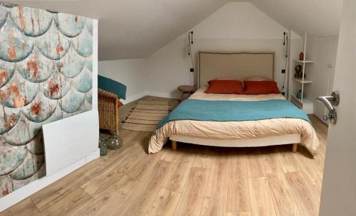 第戎Proche centre ville, gîte 4 étoiles avec piscine的一间卧室配有一张床,铺有木地板