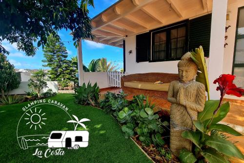 蒂纳霍Glamping Caravan Lanzarote的房屋前带雕像的花园